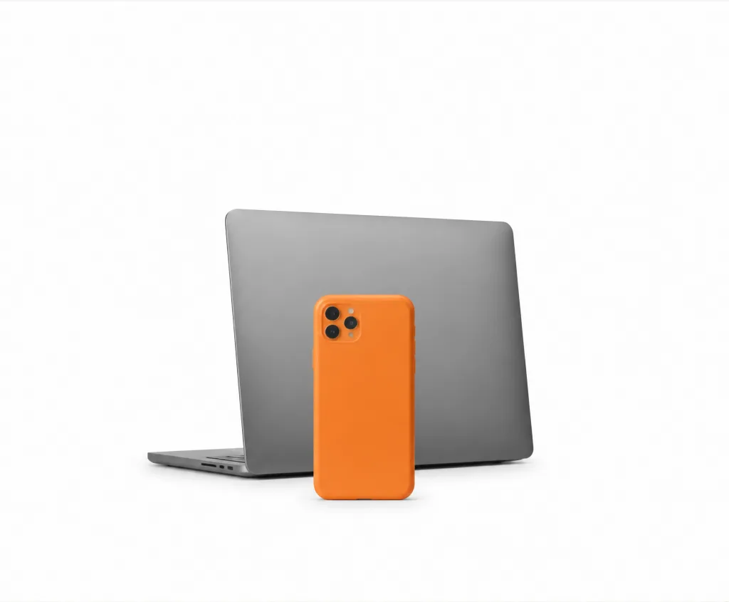 Celular laranja apoiado na tampa de um notebook cinza
